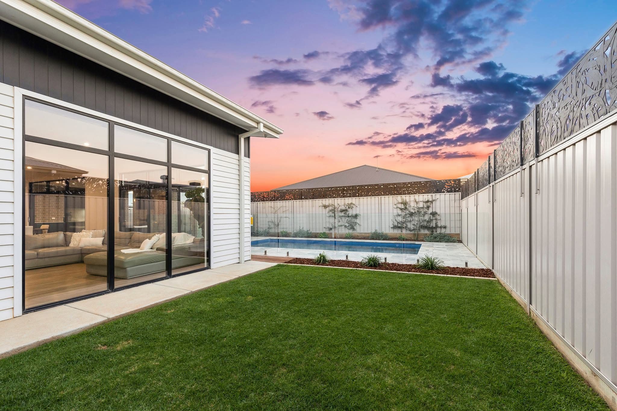 Backyard with pool, lawn and alfresco at dusk