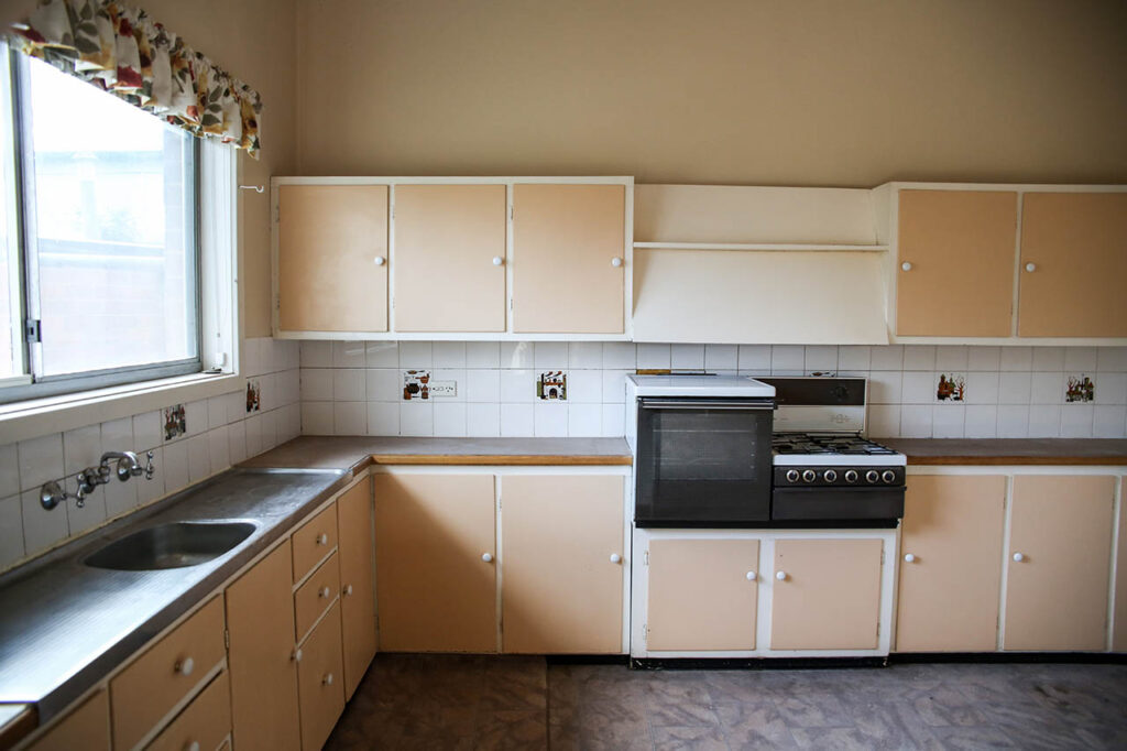 Original 1950s kitchen before renovation with cream laminate cabinetry
