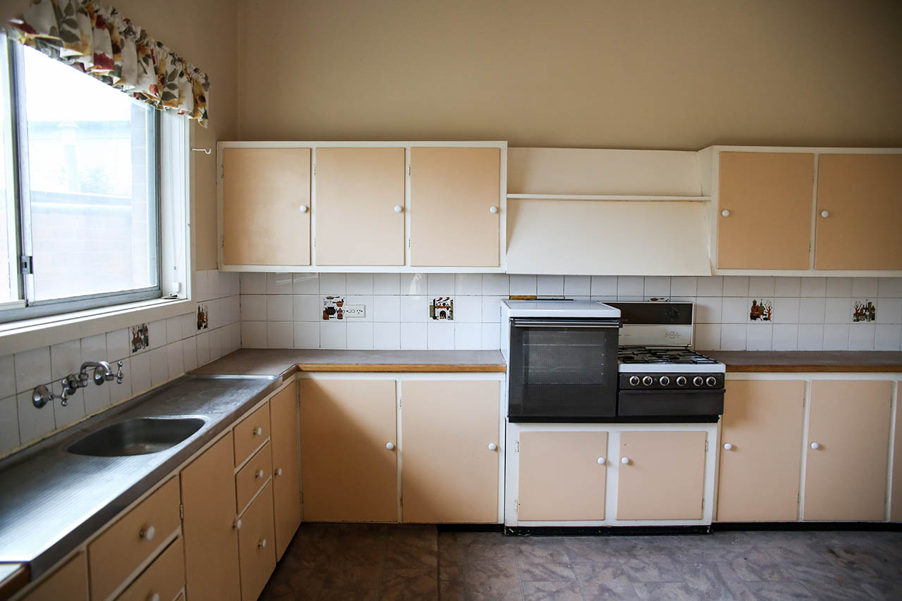 Original 1950s kitchen before renovation with cream laminate cabinetry